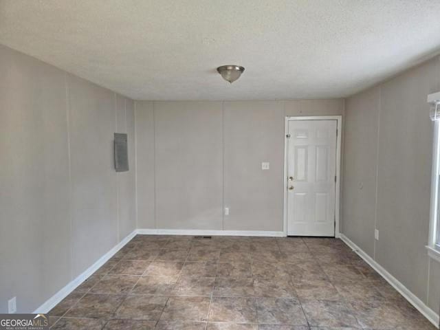 unfurnished room with a textured ceiling