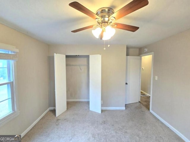 unfurnished bedroom featuring light colored carpet, ceiling fan, and a closet