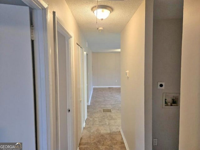 hallway featuring a textured ceiling