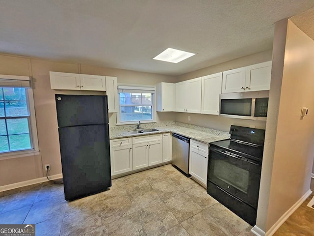 kitchen featuring sink, white cabinets, black appliances, and light stone countertops