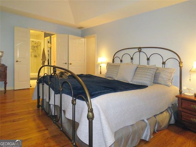 bedroom with lofted ceiling, a closet, and wood-type flooring