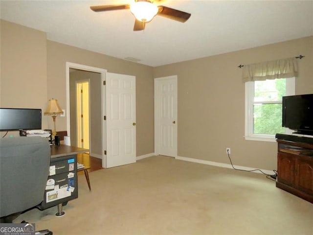 carpeted home office with ceiling fan