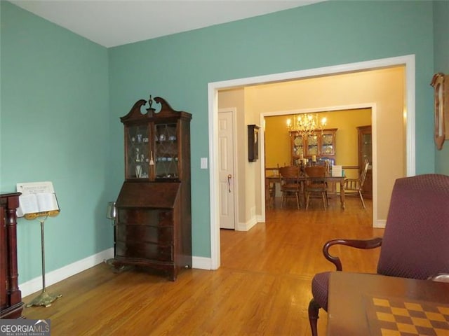 living area with hardwood / wood-style flooring and a chandelier