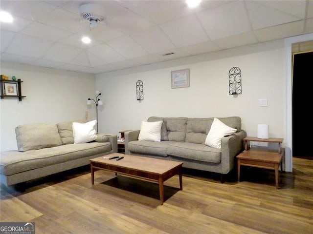 living room with a paneled ceiling and hardwood / wood-style flooring