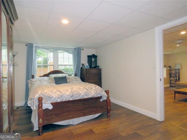 bedroom featuring dark hardwood / wood-style flooring and a drop ceiling