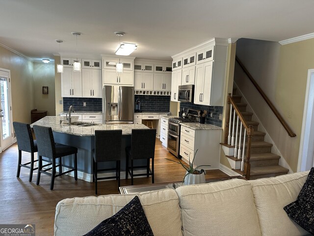 kitchen featuring crown molding, white cabinetry, stainless steel refrigerator with ice dispenser, and light hardwood / wood-style flooring