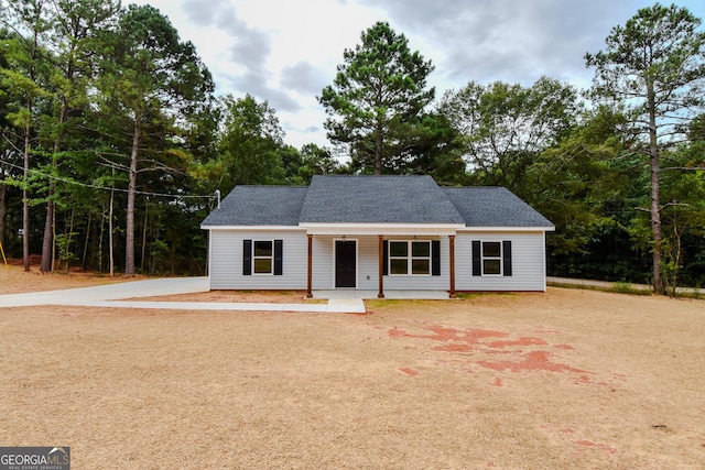 101 Alexandria Way, Thomaston, GA 30286 - view of front of house featuring dirt driveway, a porch, roof with shingles, and view of wooded area