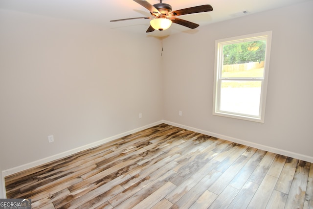 empty room with ceiling fan and light hardwood / wood-style flooring