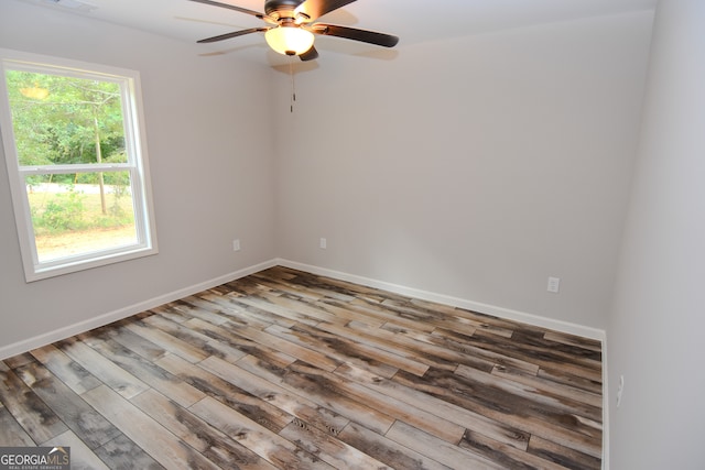 empty room featuring a wealth of natural light, ceiling fan, and hardwood / wood-style flooring