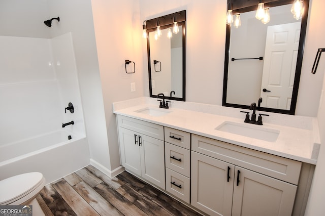 full bathroom featuring vanity, toilet, washtub / shower combination, and hardwood / wood-style floors