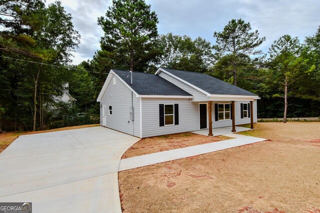 101 Alexandria Way, Thomaston, GA 30286 - view of front of house featuring concrete driveway, roof with shingles, view of scattered trees, and a porch