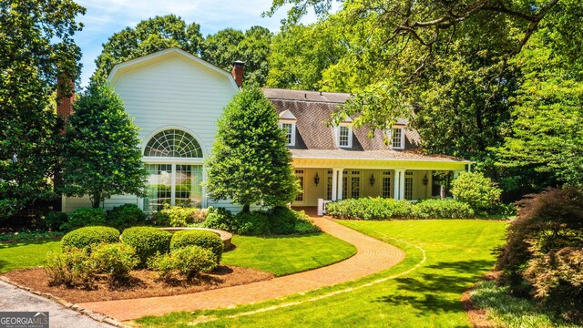 view of front of property featuring covered porch and a front lawn