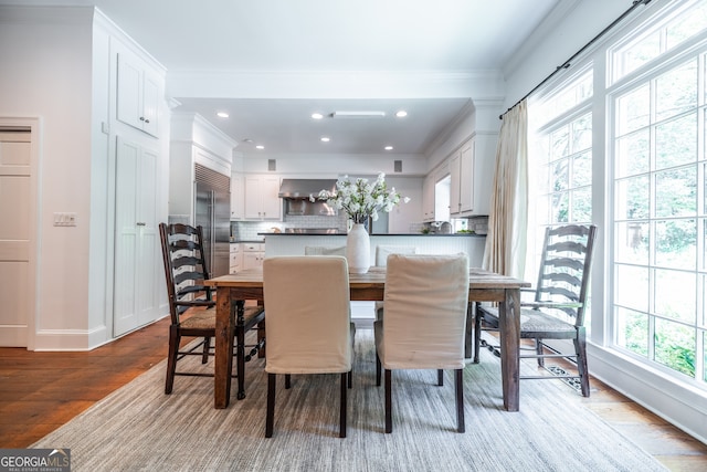 dining space featuring crown molding and light wood-type flooring