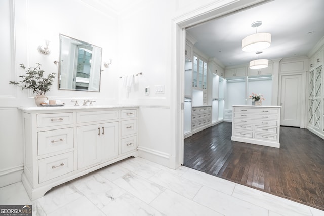 bathroom featuring crown molding, vanity, and wood-type flooring