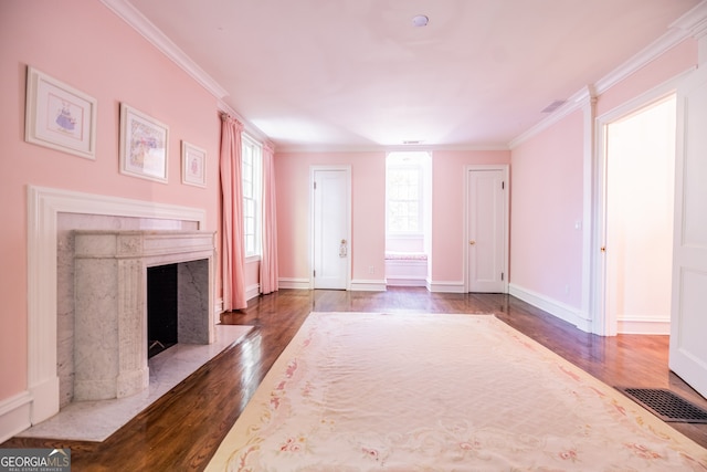 unfurnished living room with a high end fireplace, ornamental molding, and dark hardwood / wood-style floors