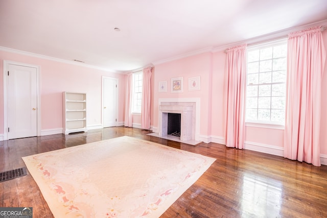 unfurnished living room with dark hardwood / wood-style floors, a high end fireplace, and a healthy amount of sunlight