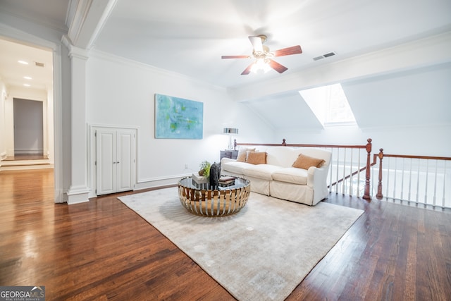 living room with ornamental molding, vaulted ceiling with skylight, ceiling fan, and dark hardwood / wood-style floors