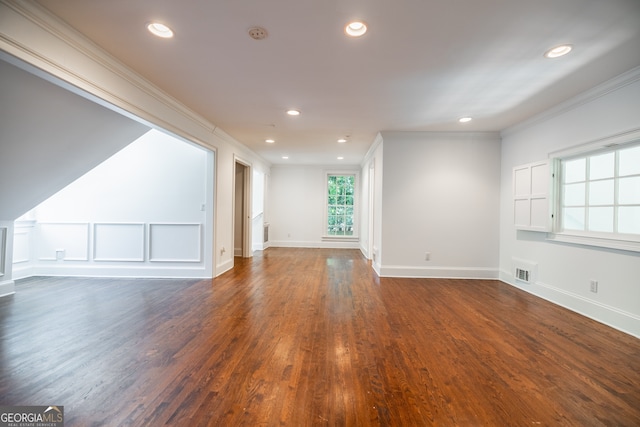 unfurnished living room with ornamental molding and dark wood-type flooring