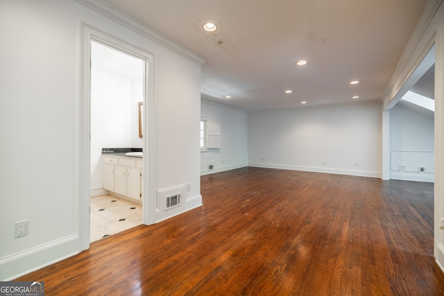 interior space featuring crown molding, vaulted ceiling, and hardwood / wood-style flooring