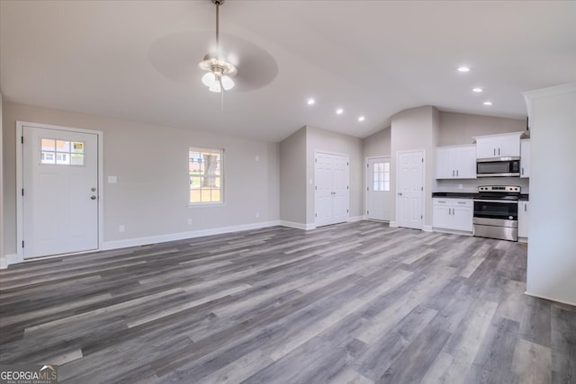 unfurnished living room featuring vaulted ceiling, hardwood / wood-style floors, and ceiling fan