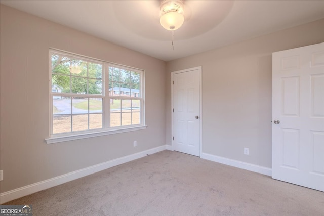 empty room featuring light carpet and ceiling fan