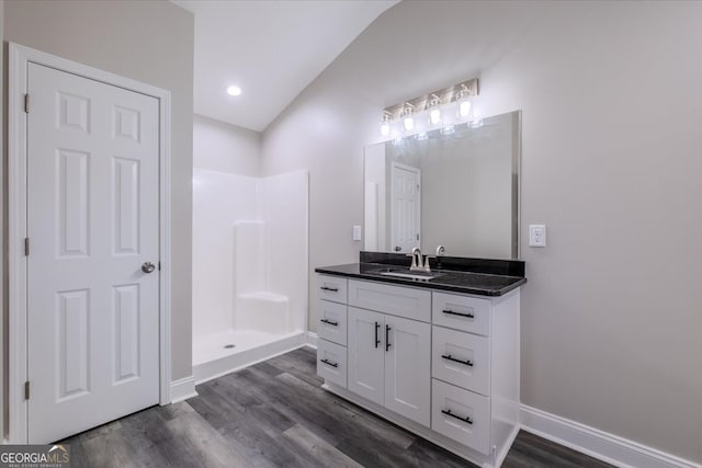 bathroom featuring lofted ceiling, vanity, hardwood / wood-style floors, and walk in shower