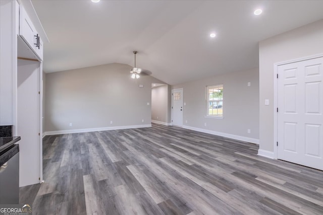 unfurnished living room with vaulted ceiling, hardwood / wood-style flooring, and ceiling fan