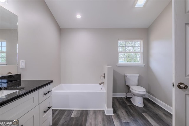 bathroom with vanity, toilet, wood-type flooring, and a bathing tub