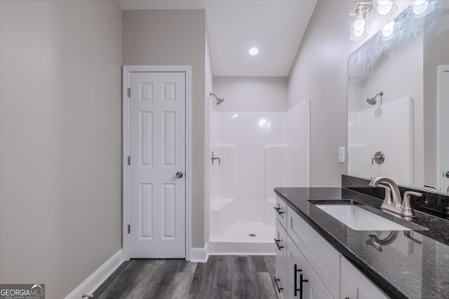 bathroom with a shower, hardwood / wood-style floors, and vanity