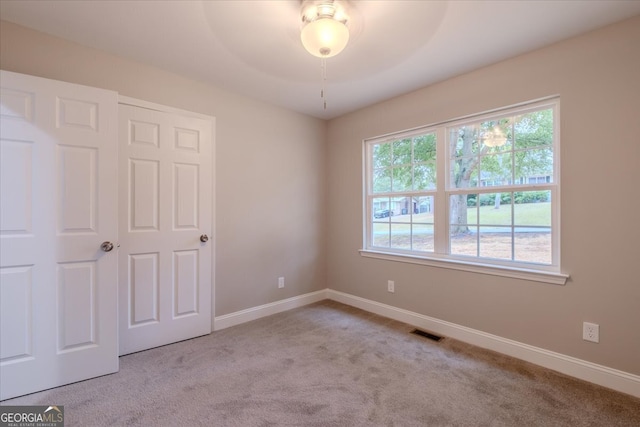 carpeted empty room with a healthy amount of sunlight