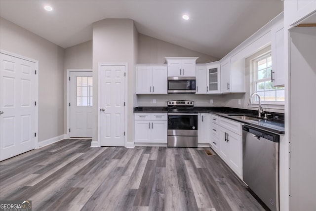 kitchen with dark wood-type flooring, sink, stainless steel appliances, and white cabinets