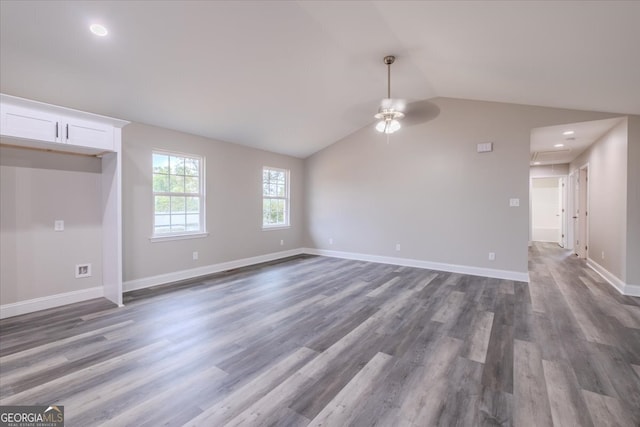 empty room with lofted ceiling, ceiling fan, and dark wood-type flooring