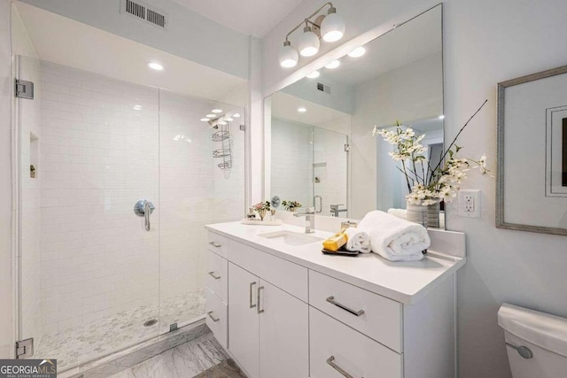 bathroom with a shower with door, vanity, and toilet