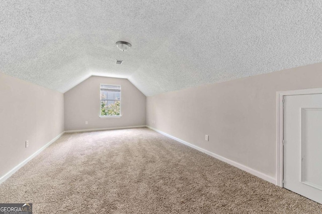 bonus room featuring lofted ceiling, a textured ceiling, and carpet flooring