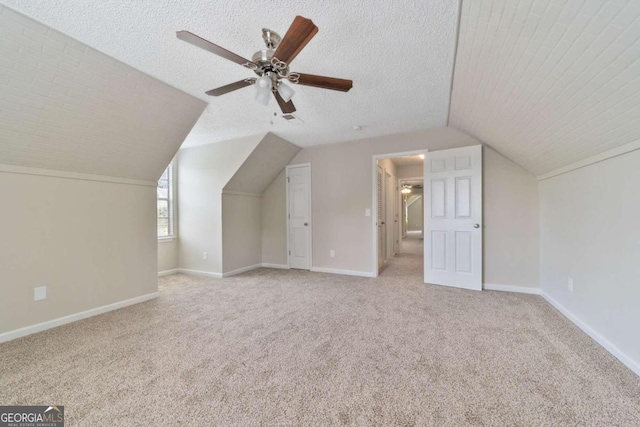 bonus room featuring light carpet, lofted ceiling, ceiling fan, and a textured ceiling