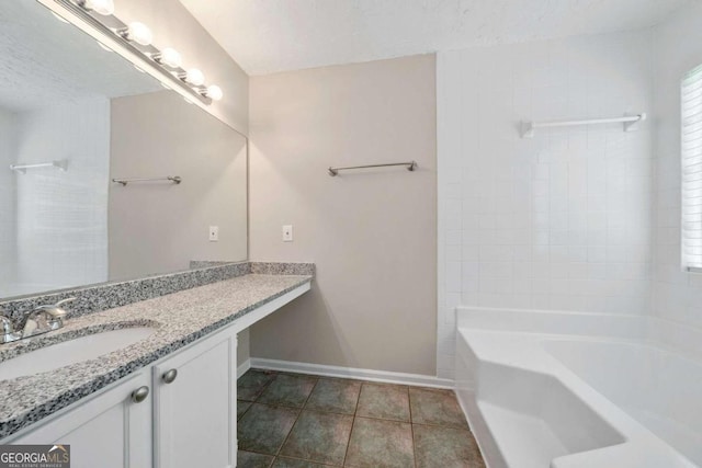 bathroom with tile patterned flooring, a textured ceiling, and vanity