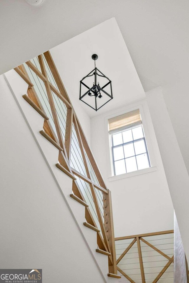 staircase with a high ceiling and an inviting chandelier