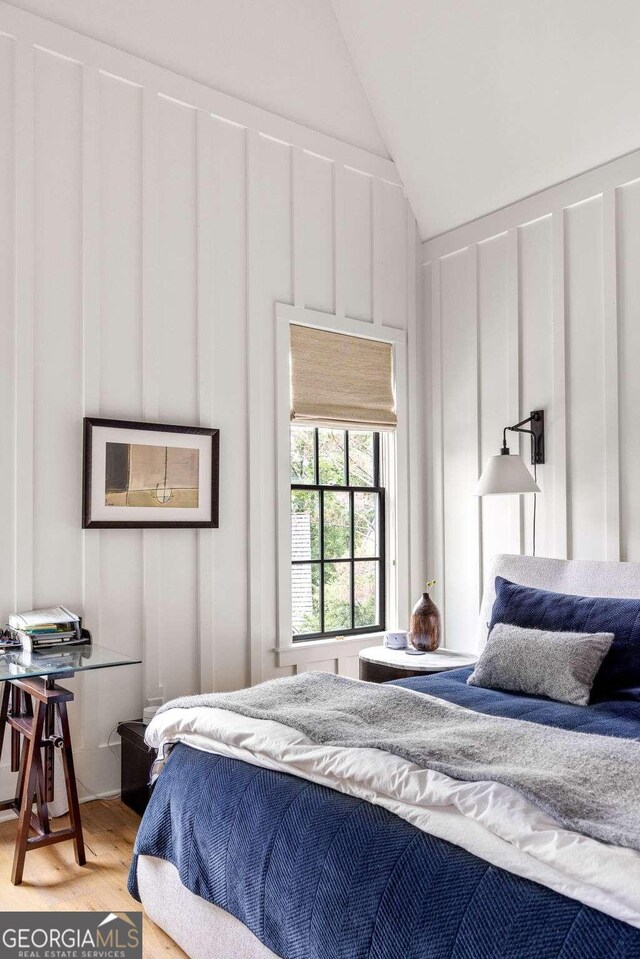 bedroom with lofted ceiling and hardwood / wood-style floors