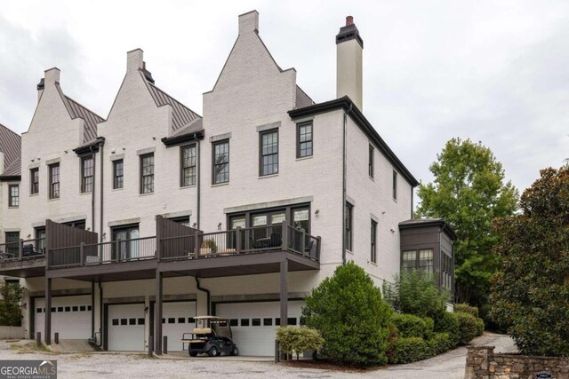 back of property with a garage and a balcony