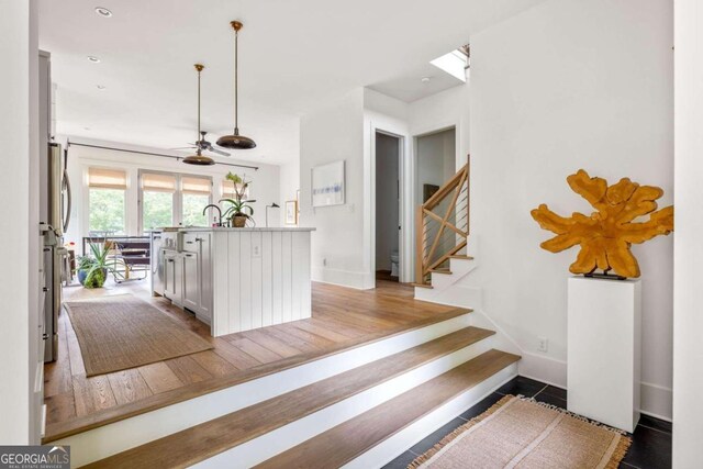 interior space featuring white cabinetry, light hardwood / wood-style floors, ceiling fan, and decorative light fixtures