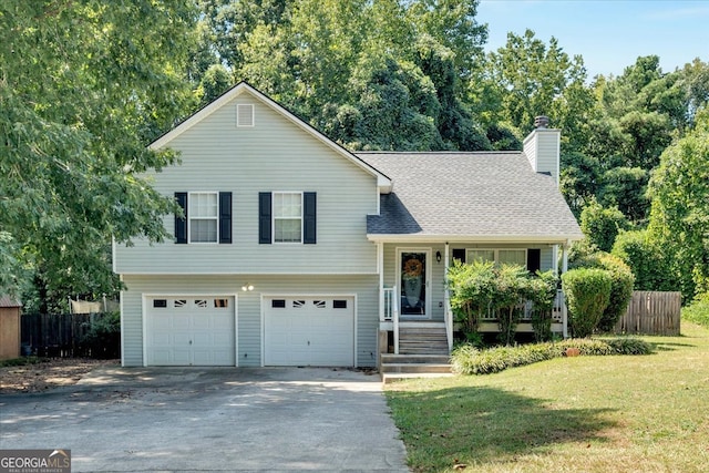 tri-level home with a porch, a garage, and a front yard