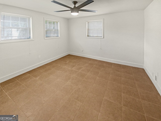 empty room featuring ceiling fan and tile patterned flooring