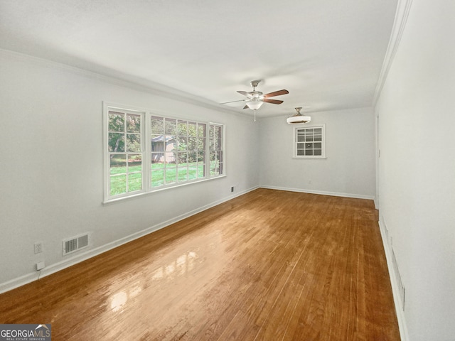 empty room with crown molding, ceiling fan, and hardwood / wood-style flooring