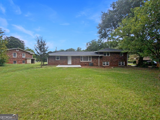 rear view of property featuring a lawn, a patio area, and central AC