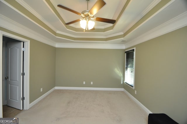 carpeted spare room featuring ceiling fan, ornamental molding, and a tray ceiling