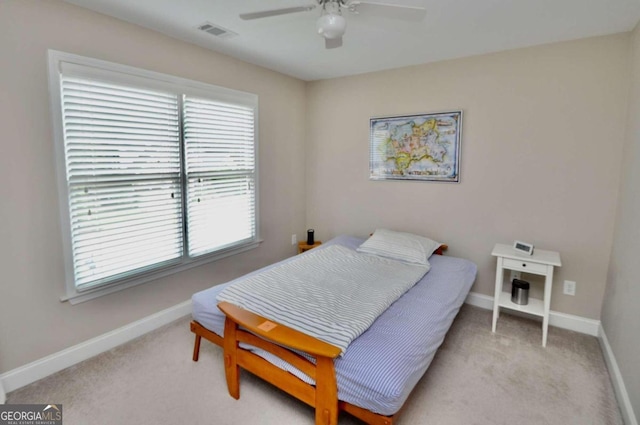 bedroom with multiple windows, light colored carpet, and ceiling fan