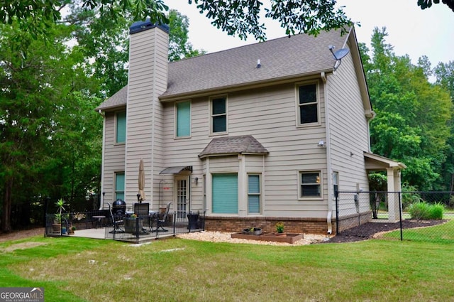 rear view of property with a patio and a lawn