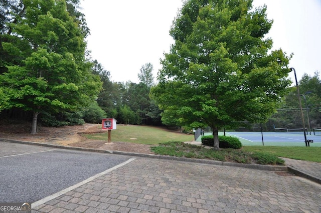 view of property's community featuring tennis court