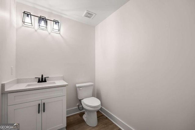 bathroom featuring vanity, toilet, and hardwood / wood-style flooring