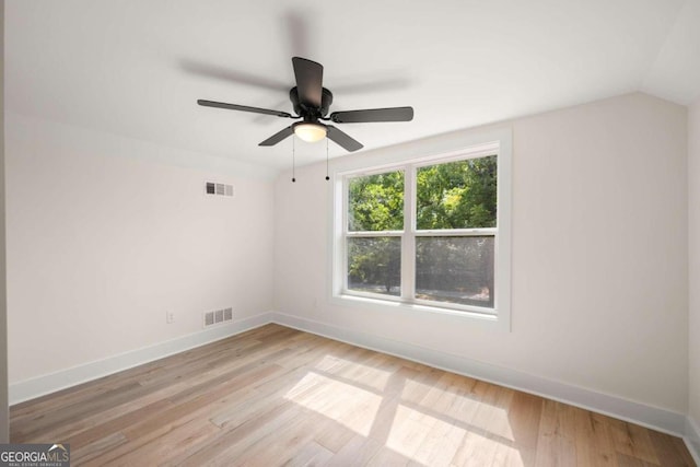 spare room featuring vaulted ceiling, light hardwood / wood-style flooring, and ceiling fan